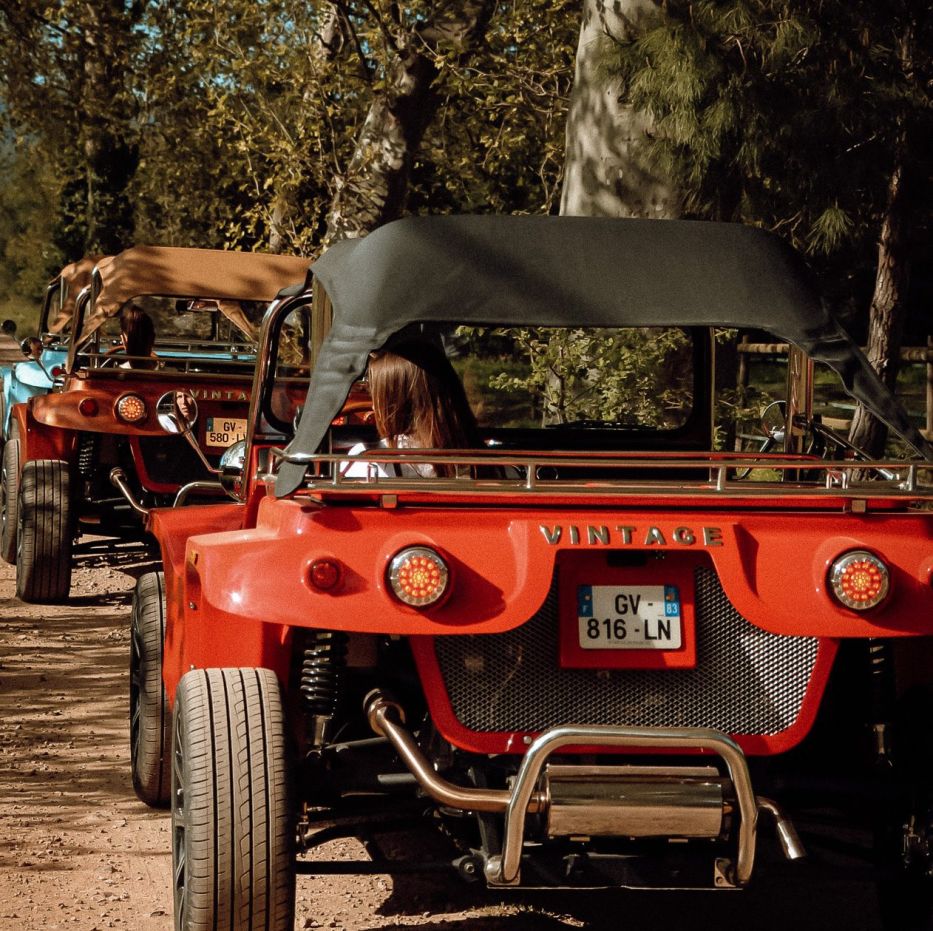 Buggys vintage rouges arrêtés sur un chemin ombragé pendant la balade